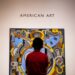 boy in red shirt standing in front of wall with UNK UNK