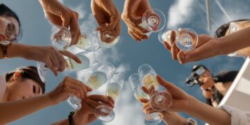 people holding clear glass bottles during daytime
